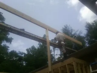 Carpenter setting a ridge beam over a new addition frame — Ice Dam Removal by Roofing Brothers in West Orange