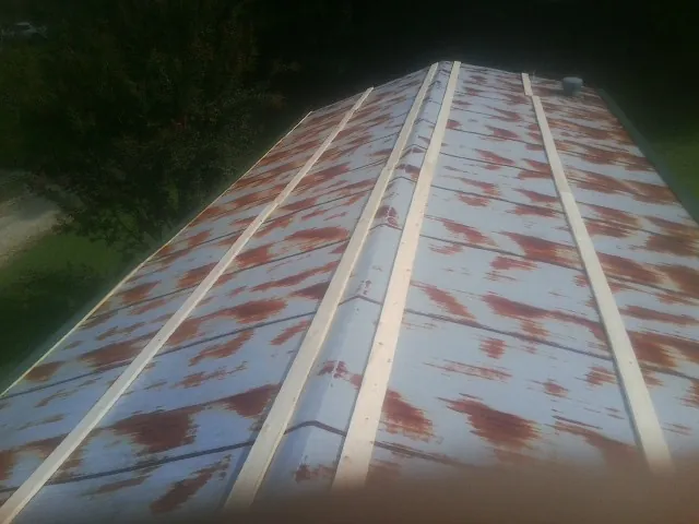 Rusted metal roof panels with new wood purlins before replacement — Storm Damage Roof Repair in West Orange by Roofing Brothers