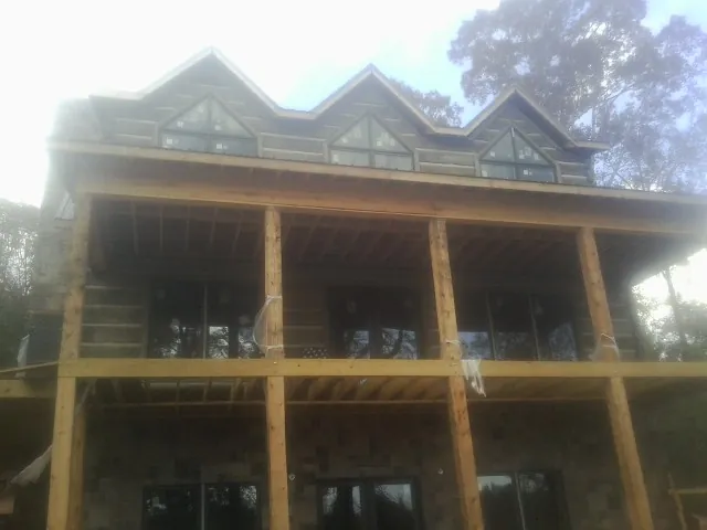 Dormers and porch framing on a large log home under construction — Roof Coating work by our crew in West Orange