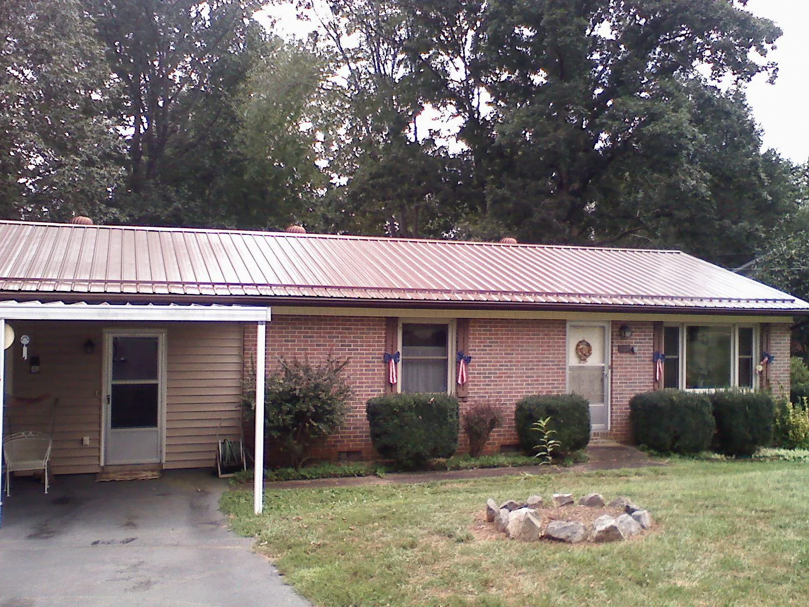 Bronze metal roof and carport on a brick ranch home — Roof Repair work by our crew in West Orange